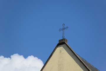 Cross at the orthodox church at blue sky background with white cloud