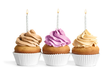 Delicious birthday cupcakes with candles on white background