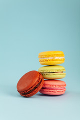 Colorful cake macaron or macaroon on blue pastel background. Different types of macaroons. Colorful almond cookies, pastel colors, vintage card, copy space for text.