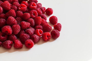 Raspberries scattered on a white background