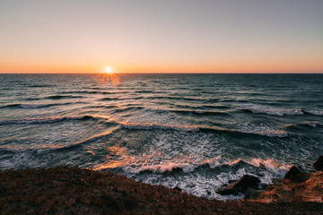 Sunrise over waves crashing the danish shore.