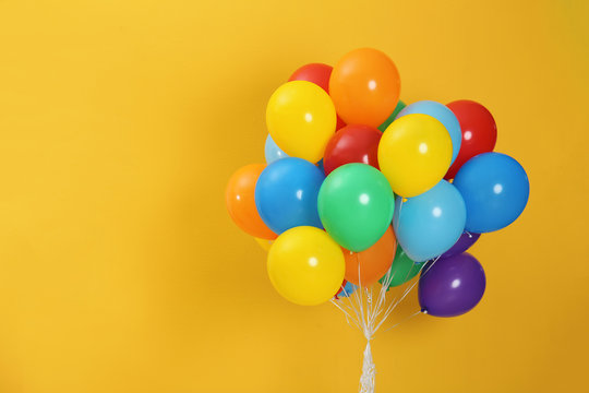 Fototapeta Bunch of bright balloons and space for text against color background