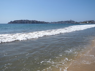 Beauty landscape of sandy beach at bay of ACAPULCO city in Mexico with white waves of Pacific Ocean