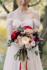 red-white bride's bouquet in the hands of the bride