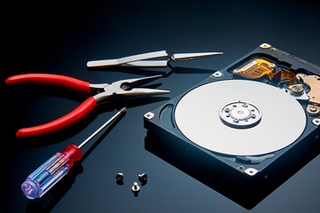 disassembled hard drive and tools are on the operating table