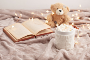 Fototapeta na wymiar Hot chocolate with marshmallows on soft plaid background with Christmas lights. Perfect winter time treat.