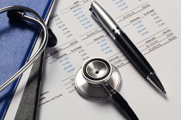 Pen And Stethoscope On Comparative Balance Sheet Close-up