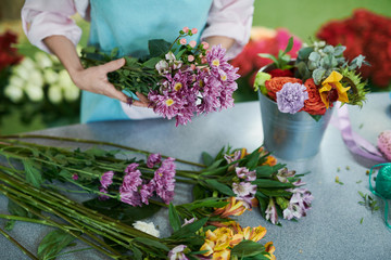 Closeup of unrecognizable woman arranging flowers in shop