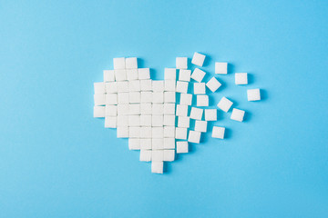 Heart made of sugar cubes on a blue background