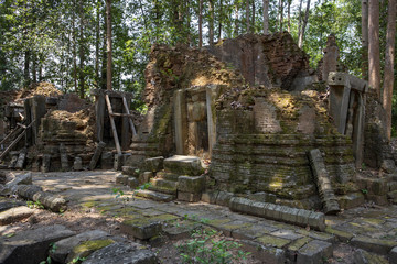 Fototapeta na wymiar Ancient stone ruin of Preah Monti temple, Roluos, Cambodia. Stone carved decor on hindu temple. Cambodian landscape
