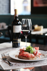 Bruschetta with prosciutto, arugula and cheese.