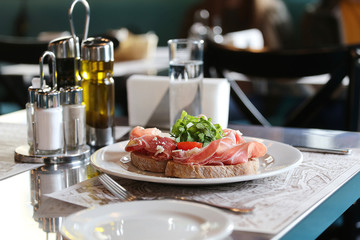 Bruschetta with prosciutto, arugula and cheese.