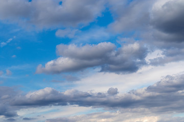 Fototapeta na wymiar Grey clouds in front of blue sky in summer