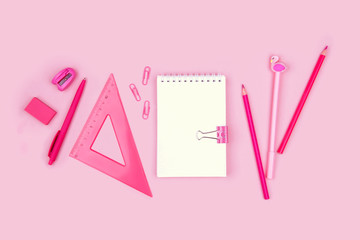 School and office supplies on pink background.