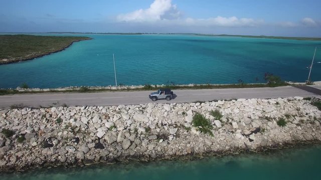 Aerial, car drives on roadway in Turks and Caicos