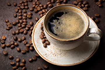Close-up of a Cup of black coffee and coffee beans on a dark background