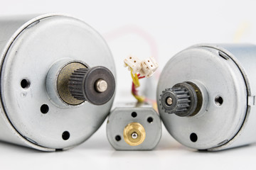 Small electric motor on a white workshop table. Electric drive used in small electrical devices.