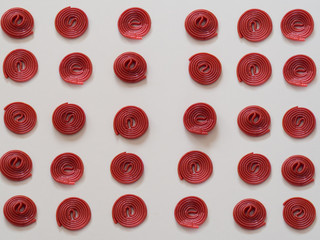 Red licorice candies pattern on white background