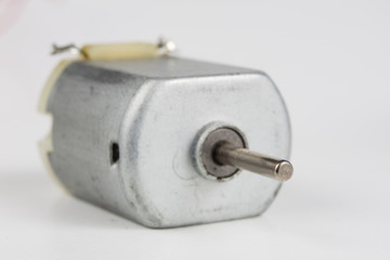 Small electric motor on a white workshop table. Electric drive used in small electrical devices.