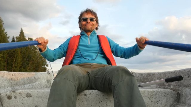 Man rowing a boat on lake at sunset
