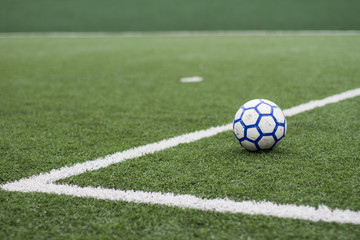 Soccer field with artificial grass, ball in the grass and lines to mark the lawn