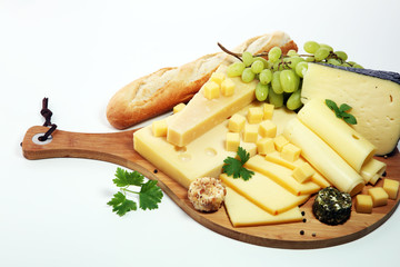 Cheese platter with different cheese and grapes.