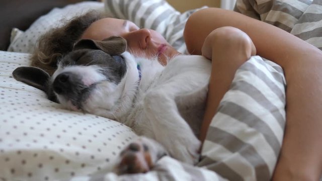 Young Woman Sleeping With Dog In Bed.