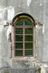 Fototapeta premium old damaged plastered brick wall with window.