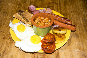 full Irish breakfast high-calorie french bean sausage toast bacon on a wooden background