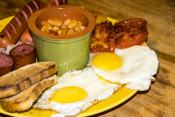 full Irish breakfast high-calorie french bean sausage toast bacon on a wooden background