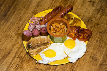 full Irish breakfast high-calorie french bean sausage toast bacon on a wooden background