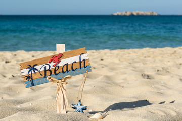 Fototapeta na wymiar Wooden beach sign on the sand