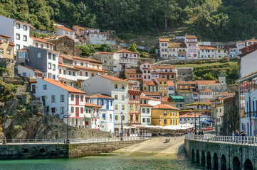 Fototapeta na wymiar The port of Cudillero village in northern Spain with its colorful white yellow and red houses, taken from the sea