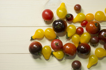 Naklejka na ściany i meble Colorful cherry tomatoes on wooden table background. Organic food