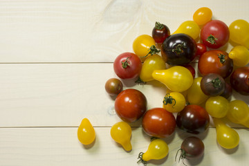 Colorful cherry tomatoes on wooden table background. Organic food