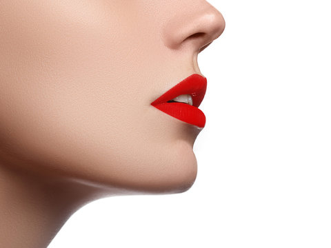 Cosmetics, makeup and trends. Bright lip gloss and lipstick on lips. Closeup of beautiful female mouth with red lip makeup. Beautiful part of female face. Perfect clean skin