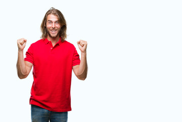 Young handsome man with long hair over isolated background celebrating surprised and amazed for success with arms raised and open eyes. Winner concept.