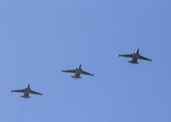 Several military fighters are flying in a formation against the blue sky