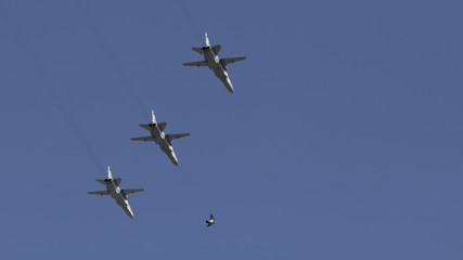 Several military fighters are flying in a formation against the blue sky