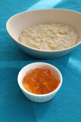 Porridge and orange jam or marmalade for morning breakfast on bright table