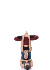 Young athletic couple practicing acroyoga. Balancing in pair.