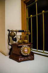 The old phone is made of wood and brass.