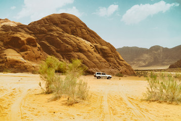 Safari jeep car in Wadi Rum desert, Jordan, Middle East, known as The Valley of the Moon. Sands,...