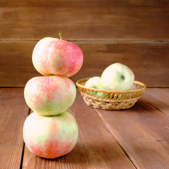 apples in a wicker basket on a wooden table
