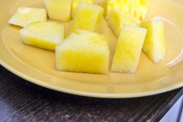half slices of  yellow watermelon without bones on a wooden background a plate