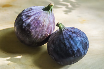 purple whole figs on  wooden background fresh ripe exotic healthy