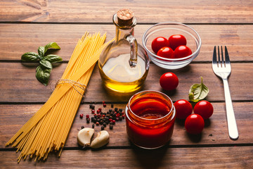 Pasta with various ingredients for cooking Italian food, on a rustic wooden table