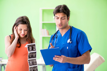 Pregnant woman visiting male gynecologyst at the clinic