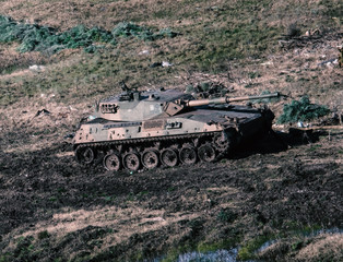 Fototapeta premium Tank Military Army Vehicle Gun armored machine cannon in a field daylight strategic transport forces