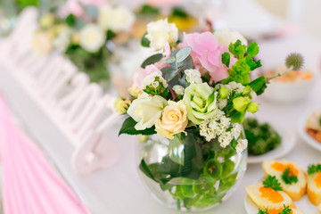 A close-up of a round transparent vase with delicate flowers and